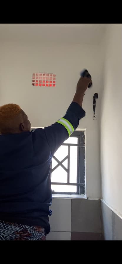 A Lavender cleaner carefully wiping a wall surface